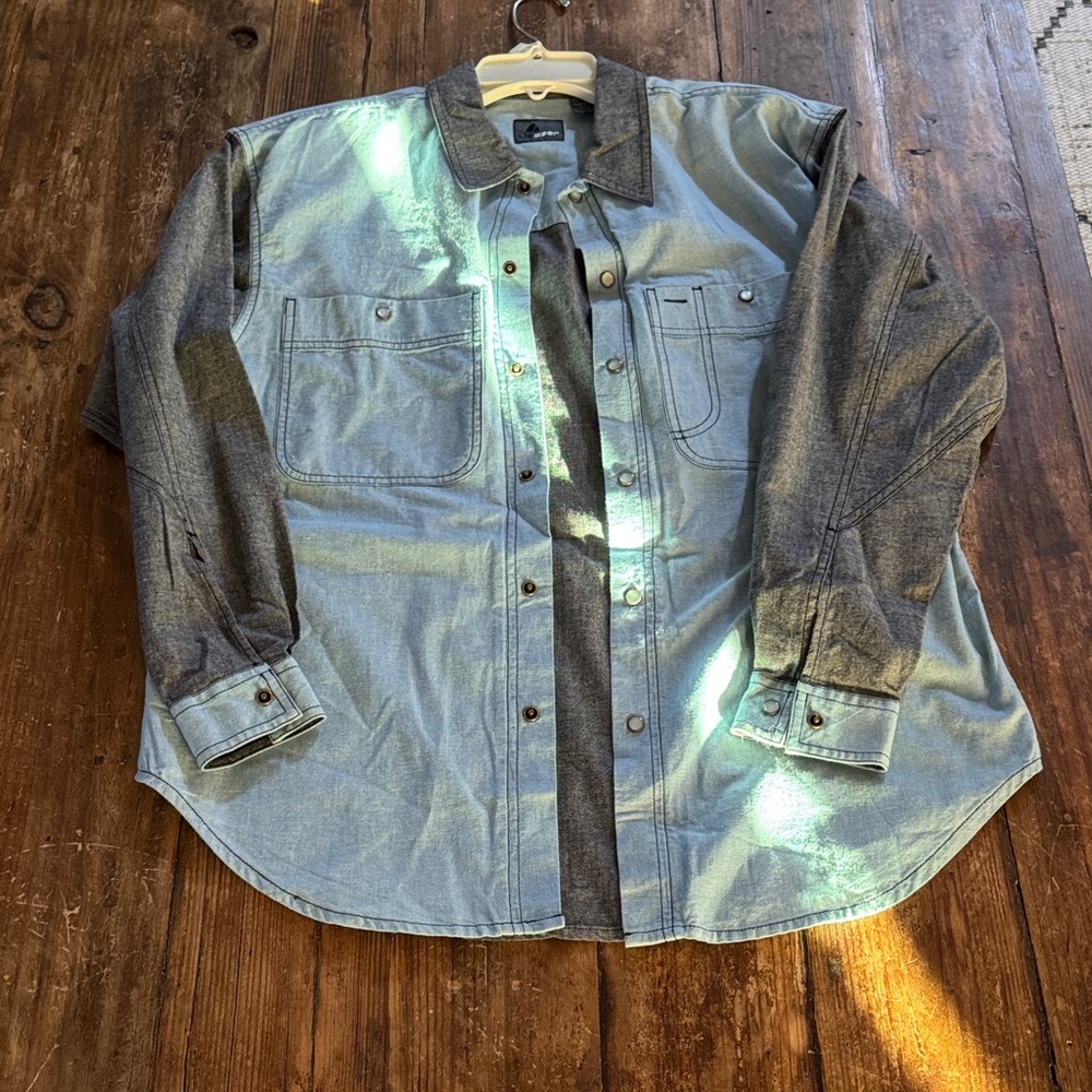 Two-tone denim button-up shirt w/dual chest pockets. Blend of light blue & grey